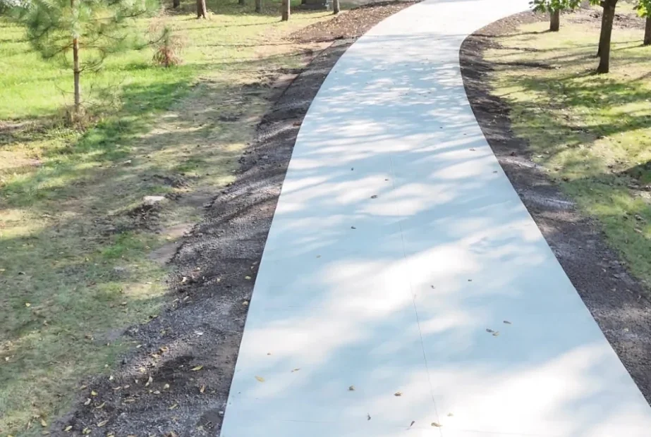 Curved concrete walking path through trees in a park in southern Minnesota